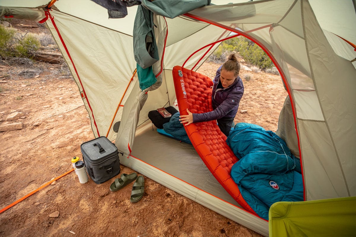 Woman putting a sleeping pad in a tent